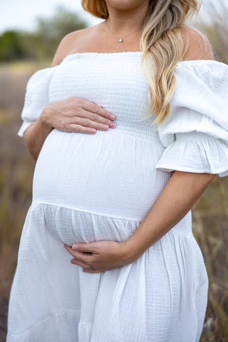 Serene pregnant mother in white dress